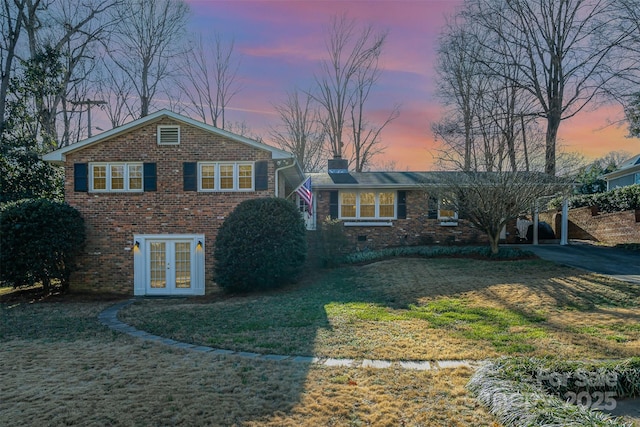 view of front of property with french doors and a yard