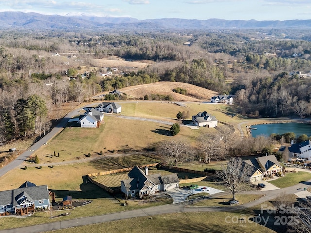 drone / aerial view with a water and mountain view