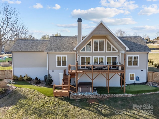 back of property featuring a hot tub and a deck