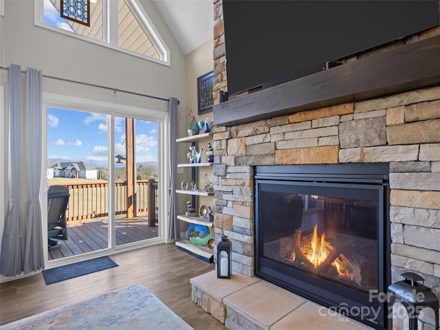 living room with lofted ceiling, hardwood / wood-style floors, and a fireplace