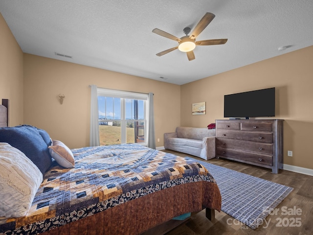 bedroom with dark wood-type flooring, a textured ceiling, and ceiling fan