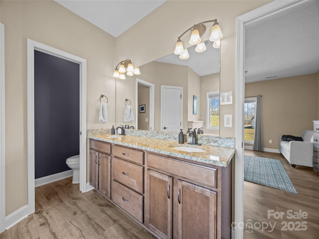 bathroom featuring vanity, a textured ceiling, wood-type flooring, and toilet