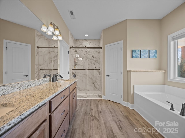 bathroom featuring independent shower and bath, vanity, and hardwood / wood-style floors