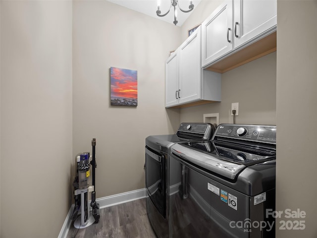 laundry room with cabinets, washing machine and dryer, dark wood-type flooring, and an inviting chandelier