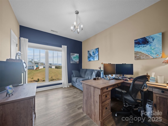 office space with a textured ceiling, a notable chandelier, and dark hardwood / wood-style flooring