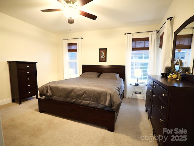 bedroom with light carpet, ceiling fan, and baseboards