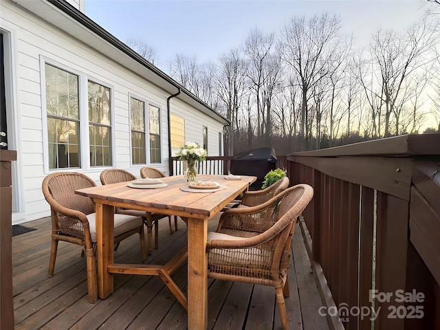 wooden deck featuring outdoor dining area and a hot tub