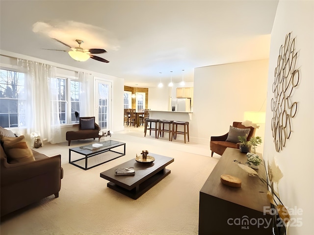 living area featuring a ceiling fan and carpet