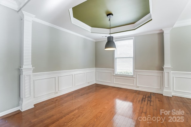 spare room with hardwood / wood-style floors, crown molding, and a tray ceiling