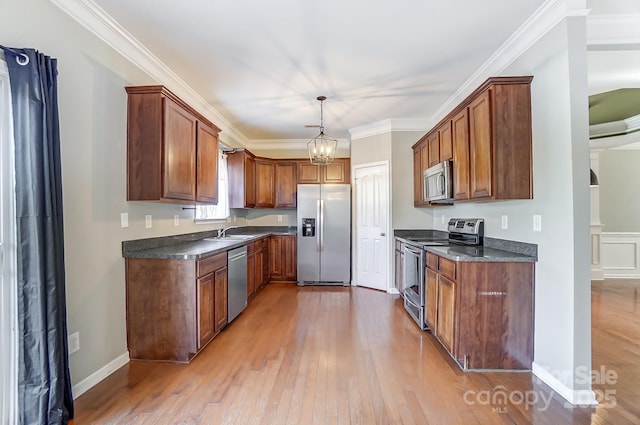 kitchen featuring sink, hanging light fixtures, stainless steel appliances, an inviting chandelier, and crown molding