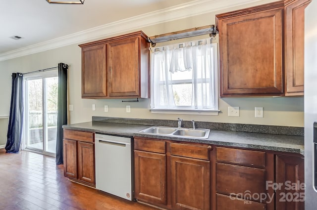 kitchen featuring dishwasher, dark hardwood / wood-style floors, crown molding, and sink