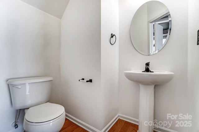 bathroom with toilet and wood-type flooring