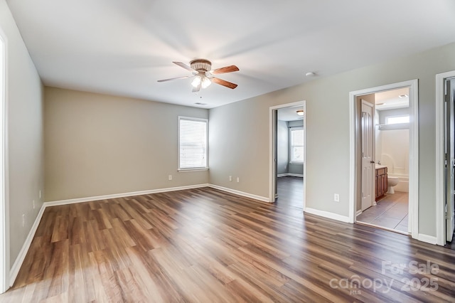 unfurnished bedroom featuring ensuite bath, ceiling fan, and wood-type flooring