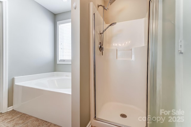 bathroom with tile patterned floors and shower with separate bathtub