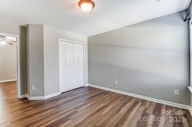 unfurnished bedroom with dark hardwood / wood-style floors and a closet