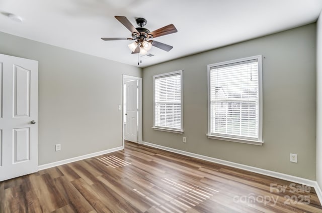 empty room with ceiling fan and hardwood / wood-style floors