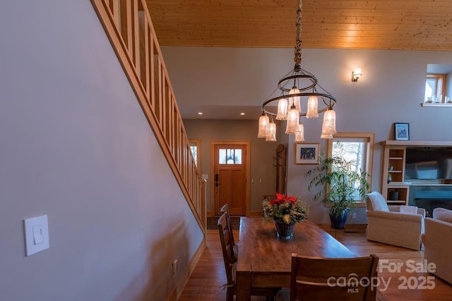 dining space featuring high vaulted ceiling, wood-type flooring, a notable chandelier, and wood ceiling