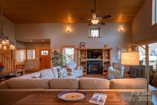 living room with ceiling fan, wood ceiling, plenty of natural light, and high vaulted ceiling