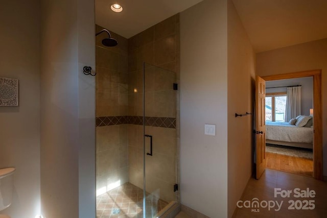 bathroom featuring toilet, walk in shower, and tile patterned flooring