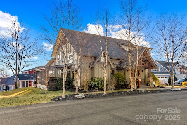 view of front of property with a sunroom and a front yard