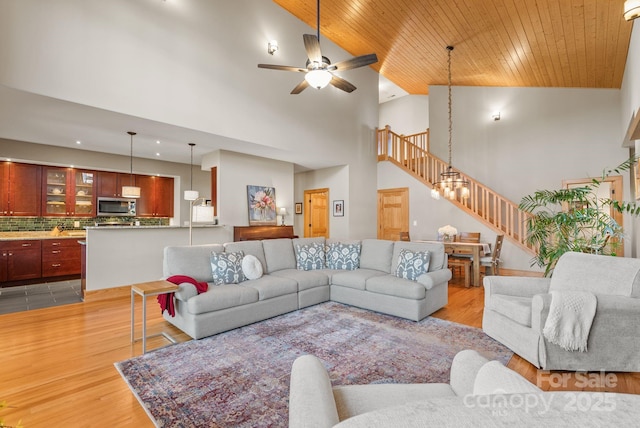 living room featuring wood ceiling, light hardwood / wood-style flooring, high vaulted ceiling, and ceiling fan