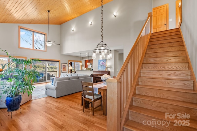 stairs with ceiling fan, high vaulted ceiling, hardwood / wood-style floors, and wooden ceiling