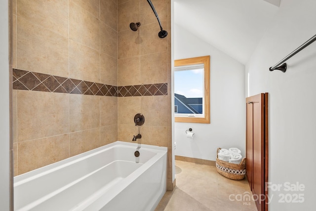 bathroom with tile patterned flooring, tiled shower / bath, and lofted ceiling