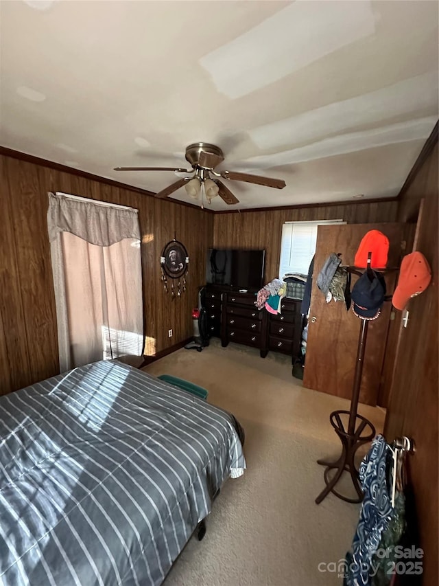 carpeted bedroom featuring ceiling fan and wooden walls