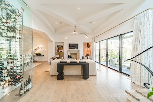 living room featuring beamed ceiling, high vaulted ceiling, and light hardwood / wood-style floors