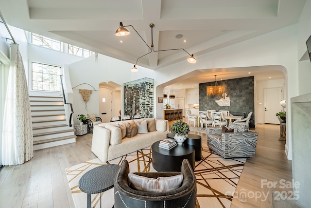 living room featuring coffered ceiling, light hardwood / wood-style flooring, and beamed ceiling