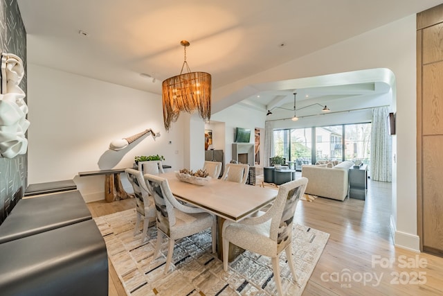 dining room with vaulted ceiling, a chandelier, and light hardwood / wood-style floors