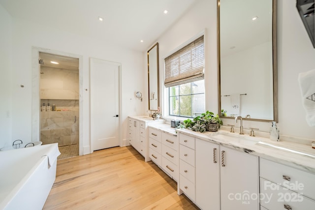 bathroom featuring vanity, independent shower and bath, and wood-type flooring