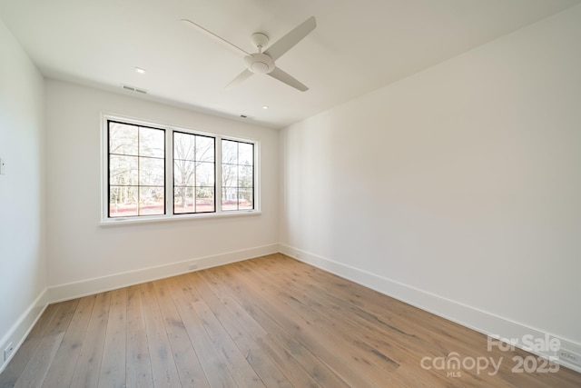 empty room with ceiling fan and light hardwood / wood-style floors