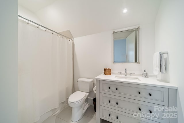 bathroom with tile patterned flooring, vanity, vaulted ceiling, and toilet