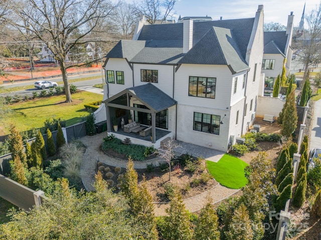 back of property with a yard and a patio