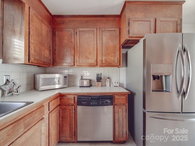 kitchen featuring backsplash, sink, and appliances with stainless steel finishes