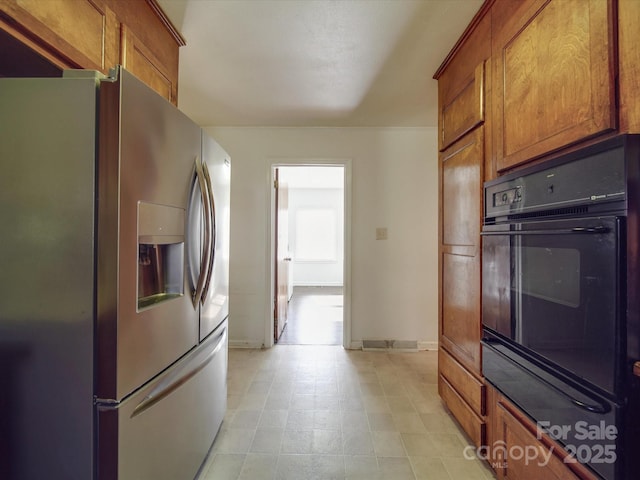 kitchen featuring black oven and stainless steel fridge