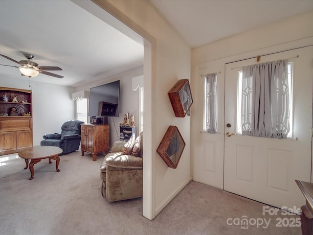 carpeted foyer with ceiling fan