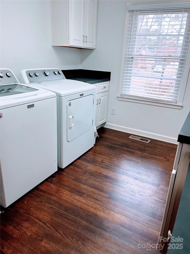 washroom featuring a healthy amount of sunlight, cabinets, separate washer and dryer, and dark wood-type flooring