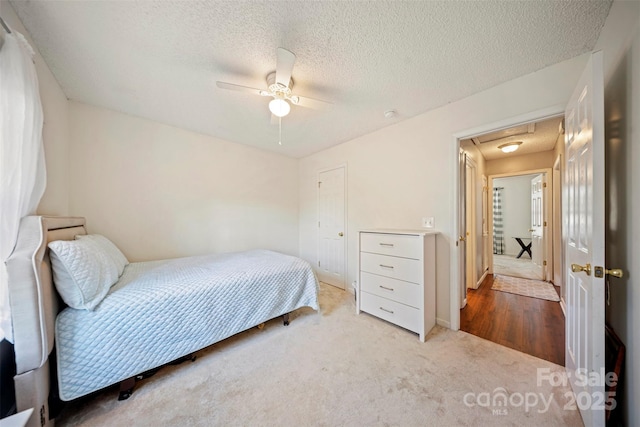 bedroom with carpet, ceiling fan, and a textured ceiling