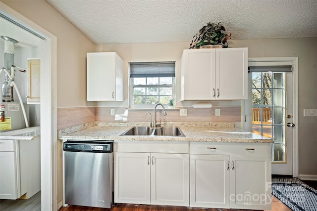 kitchen with light stone countertops, a textured ceiling, sink, dishwasher, and white cabinetry