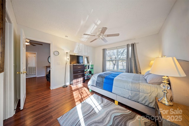 bedroom with dark hardwood / wood-style flooring, a textured ceiling, and ceiling fan