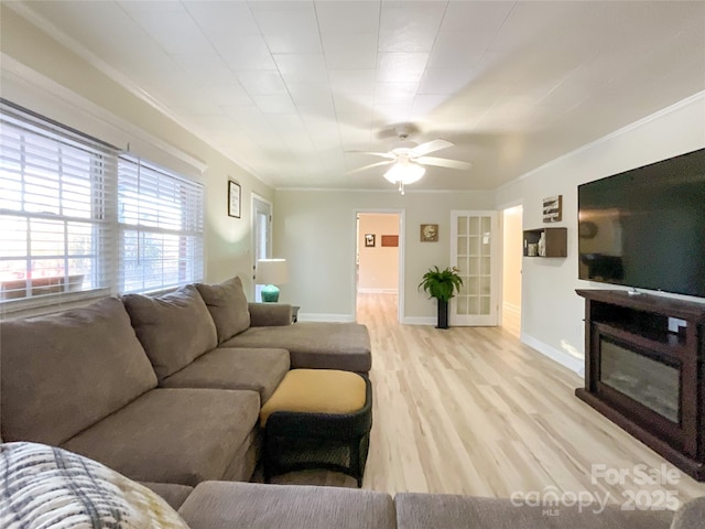 living room featuring light wood-type flooring, ceiling fan, and ornamental molding