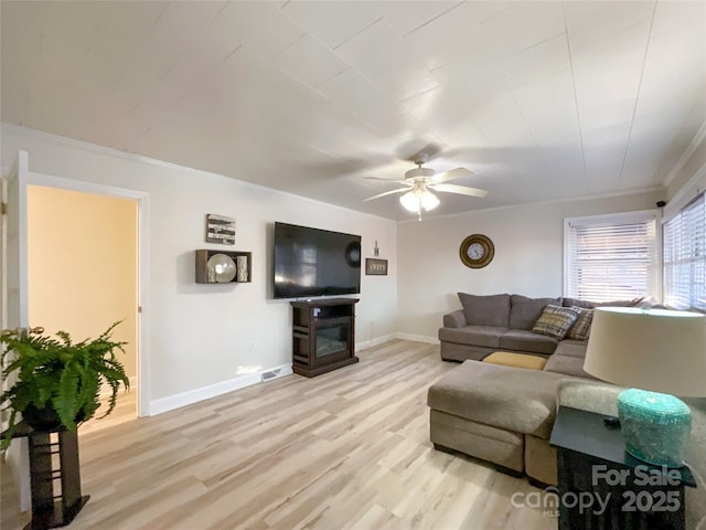 living room featuring light hardwood / wood-style flooring, ceiling fan, and crown molding