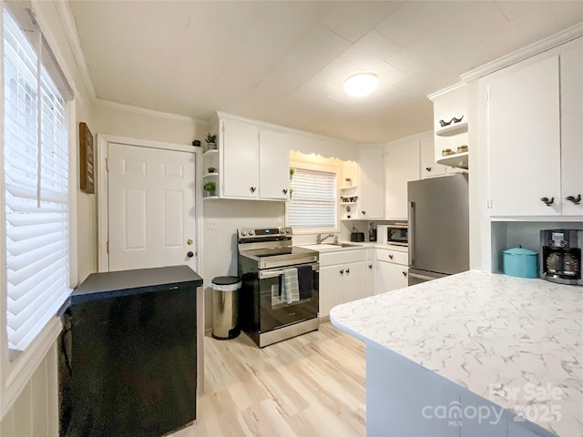 kitchen with light hardwood / wood-style floors, white cabinets, stainless steel appliances, and ornamental molding