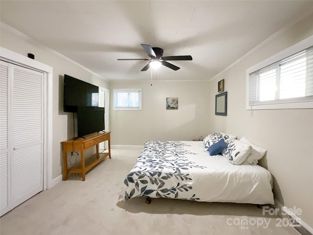 bedroom featuring ceiling fan, ornamental molding, multiple windows, light colored carpet, and a closet