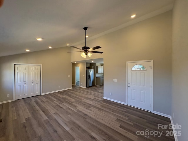 unfurnished living room with ceiling fan, dark hardwood / wood-style flooring, and high vaulted ceiling