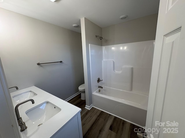 full bathroom with hardwood / wood-style flooring, vanity, toilet, and shower / tub combination