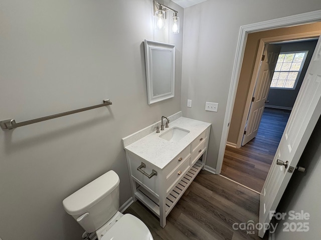 bathroom with vanity, hardwood / wood-style flooring, and toilet