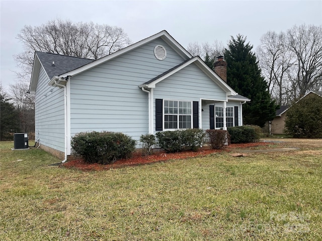 view of front of house with cooling unit and a front lawn